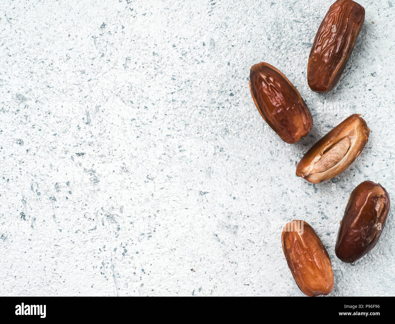 Getrocknete Datteln auf grauem Zement, Copyspace Stockfoto