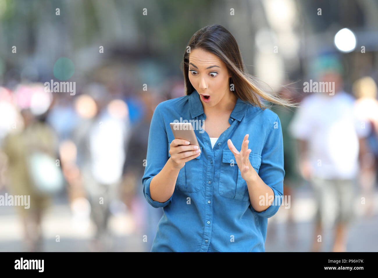 Schockiert Frau liest smart phone Nachrichten gehen auf die Straße Stockfoto