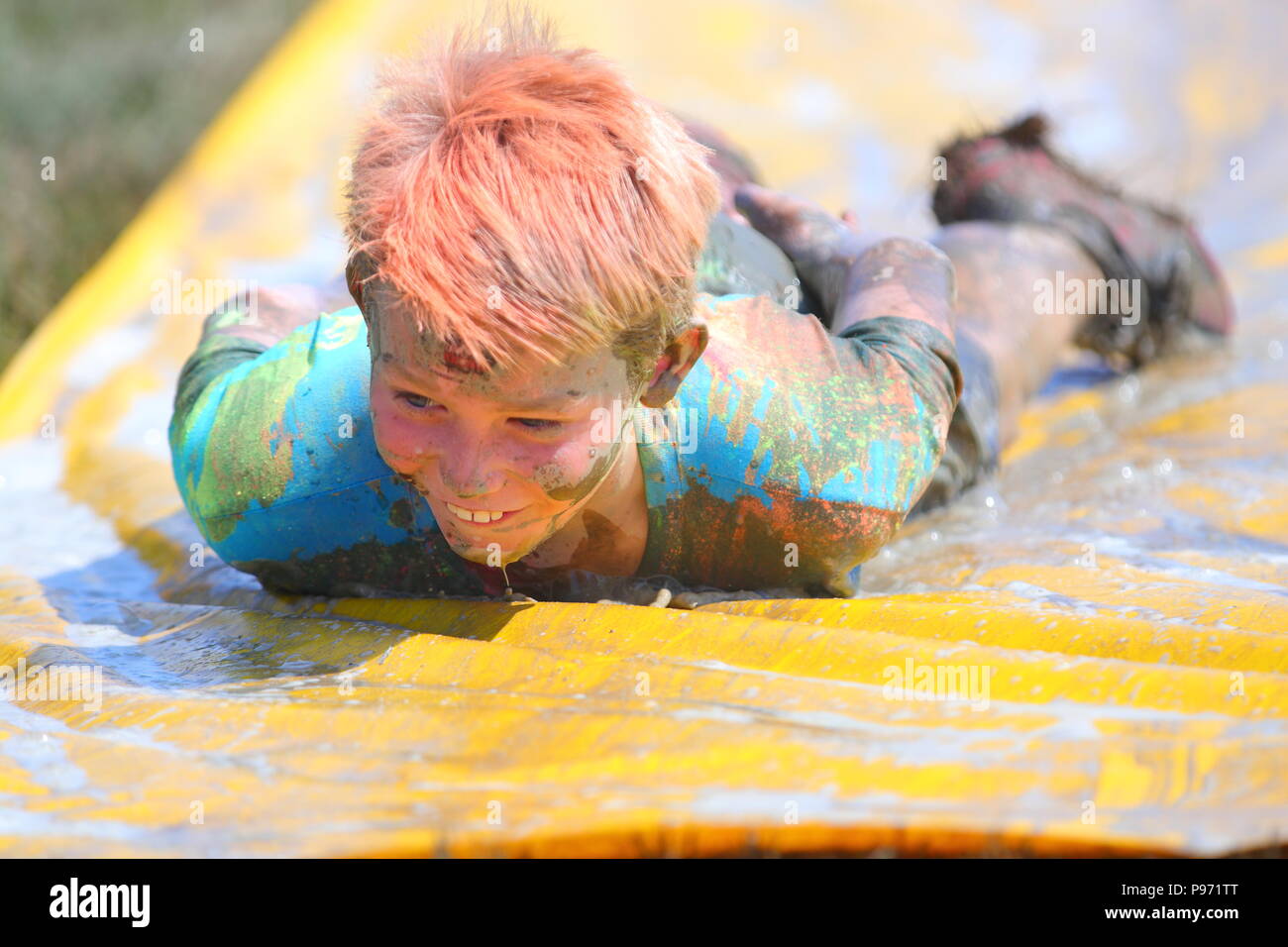 Ein Junge der Spaß auf einem Schlamm schieben und einen der vielen Hindernisse während eines Jungen Mudders Ereignis ist ein 2,5 & 5 k schlammigen Parcours. Stockfoto