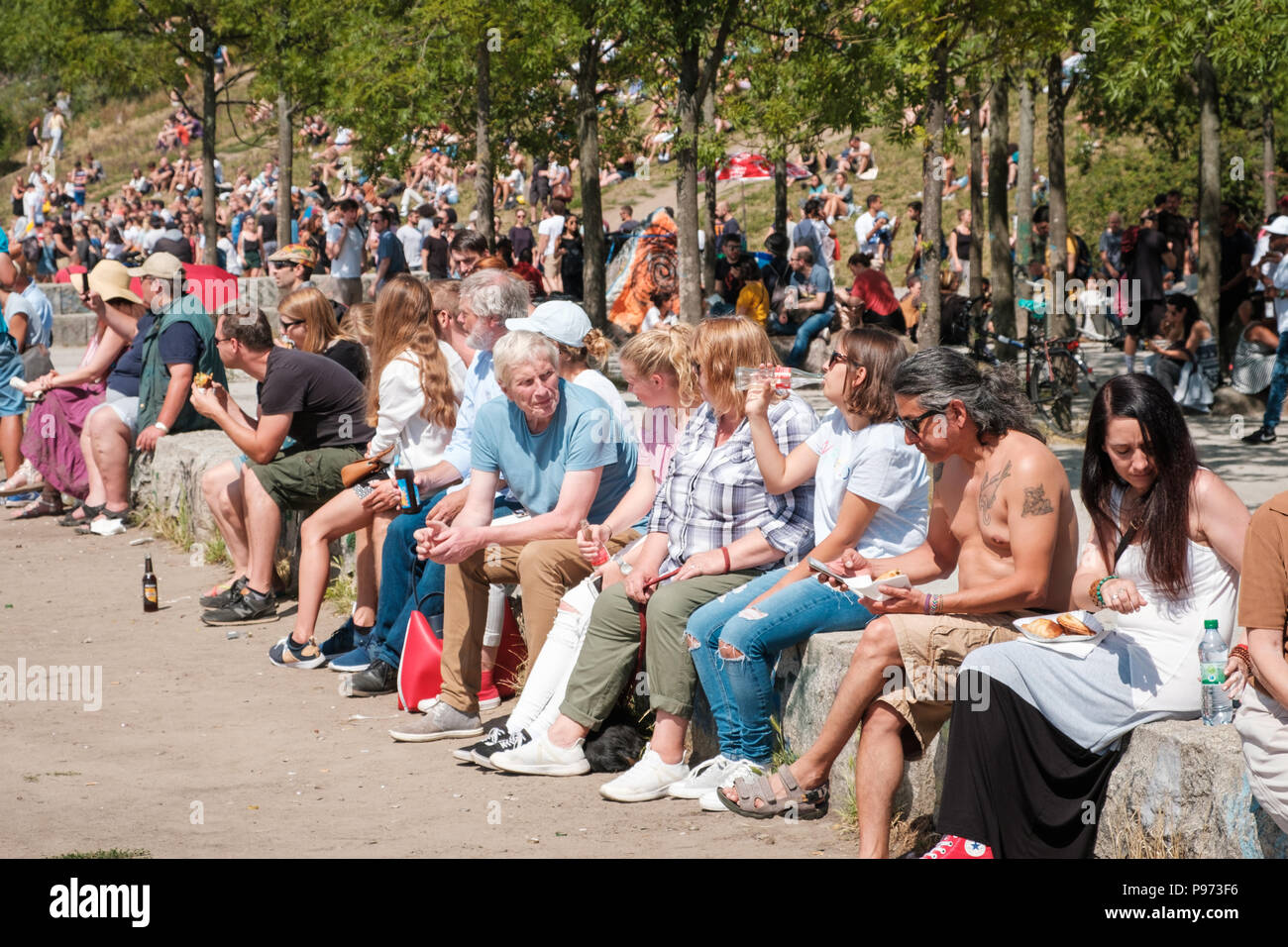 Berlin, Deutschland - Juli 2018: Viele Leute sitzen zusammen trinken in belebten Park (Mauerpark) an einem sonnigen Sommertag Stockfoto