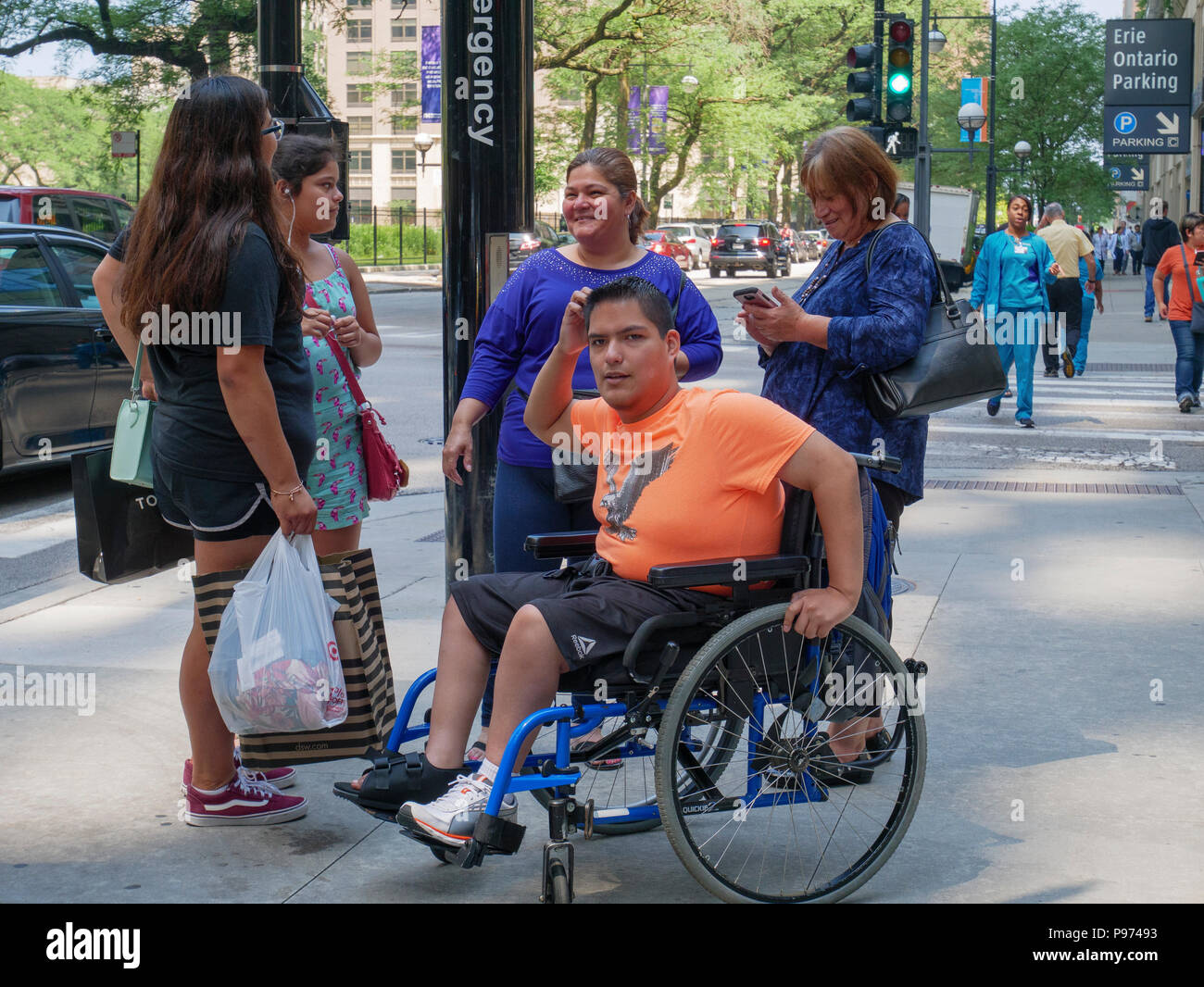 Mann im Rollstuhl mit Freunden. Michigan Avenue, Chicago, Illinois. Stockfoto