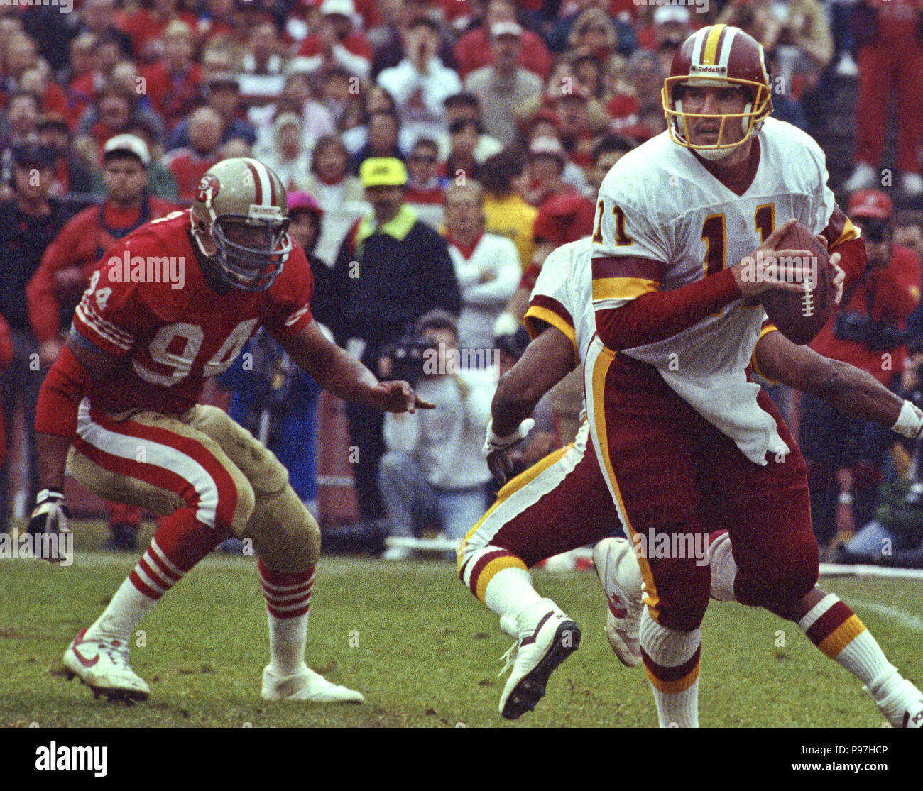 San Francisco, Kalifornien, USA. 12 Jan, 1991. San Francisco 49ers vs Washington Redskins an Candlestick Park Samstag, 12. Januar 1991. 49ers schlagen Redskins 28-10. Redskin quarterback Mark Rypien (11) bewegt sich weg von 49er defensiven Ende Charles Haley Credit: Al Golub/ZUMA Draht/Alamy leben Nachrichten Stockfoto