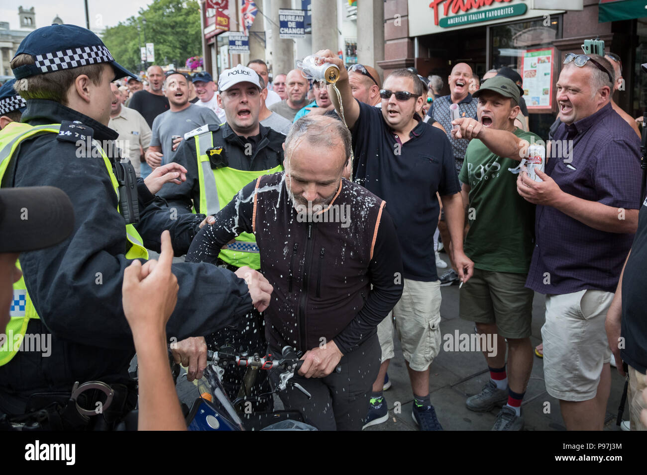 London, Großbritannien. 14. Juli 2018. Mitglieder der rechtsextremen Angriff und Bier über einen linken Gießen-Opposition Demonstrant, wie Tausende von pro-Trump Unterstützer melden Sie mit "Freien Tommy Robinson" Demonstranten in Whitehall zu sammeln. Credit: Guy Corbishley/Alamy leben Nachrichten Stockfoto