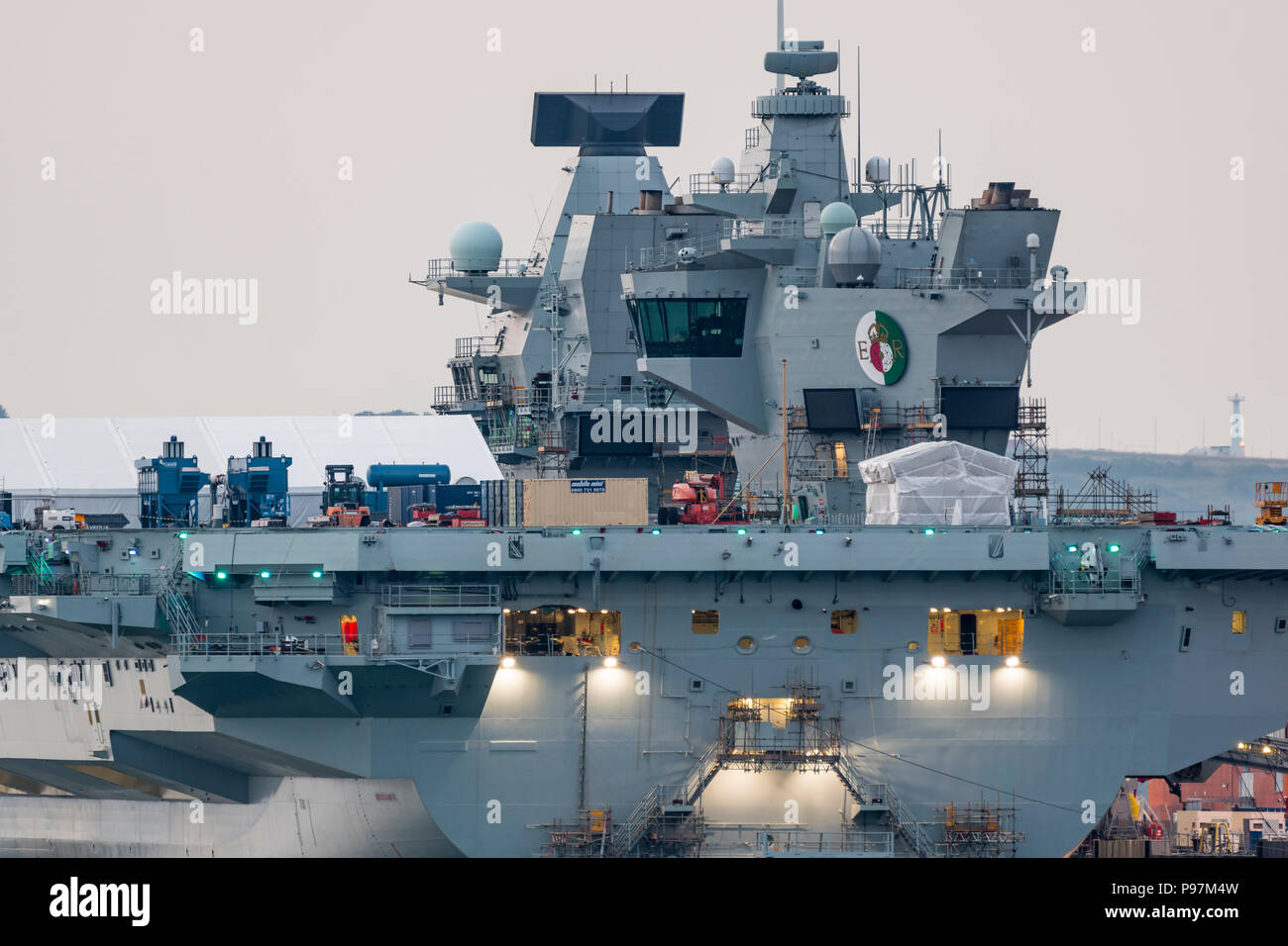 HMS Queen Elizabeth Flugzeugträger, größten und neuesten Kriegsschiff der Royal Navy, in der Dämmerung in den Docks von Portsmouth, Hampshire, England, UK. Stockfoto
