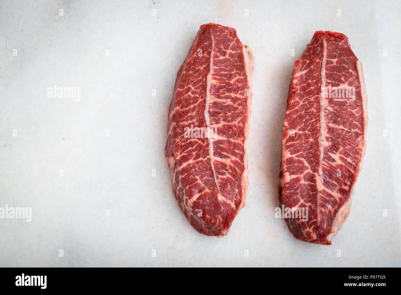 Rohe frische Fleisch Top Blade Steaks auf hellen Hintergrund. Ansicht von oben mit der Kopie Raum Stockfoto