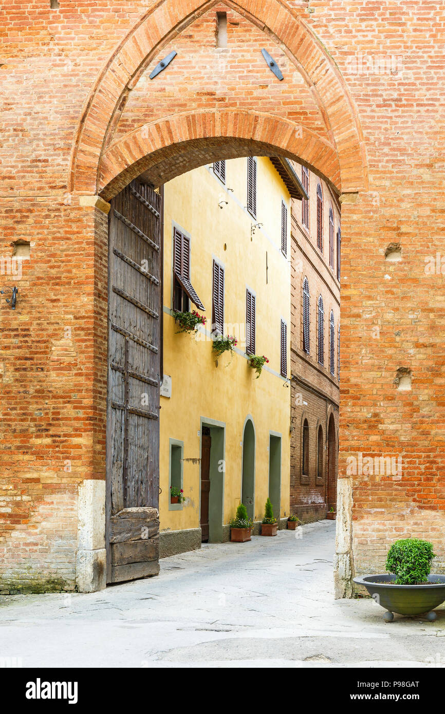 Straße durch ein Stadttor zu einem alten italienischen Dorf Stockfoto