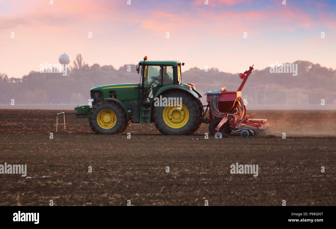 Traktor auf dem Feld bei Sonnenuntergang Stockfoto