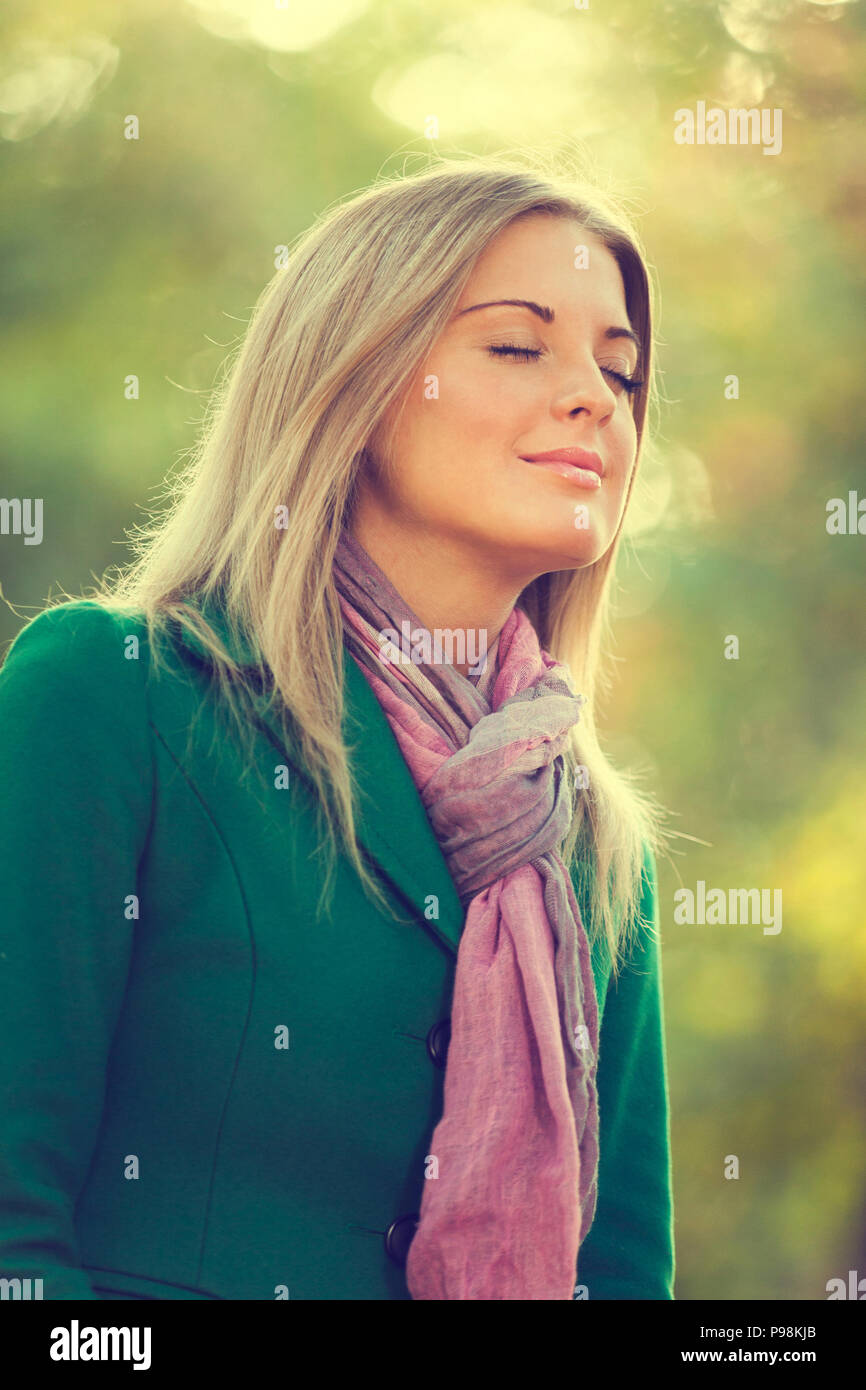Junge Frau genießen Sie die frische Luft im Herbst, absichtlich abgeschwächt. Stockfoto