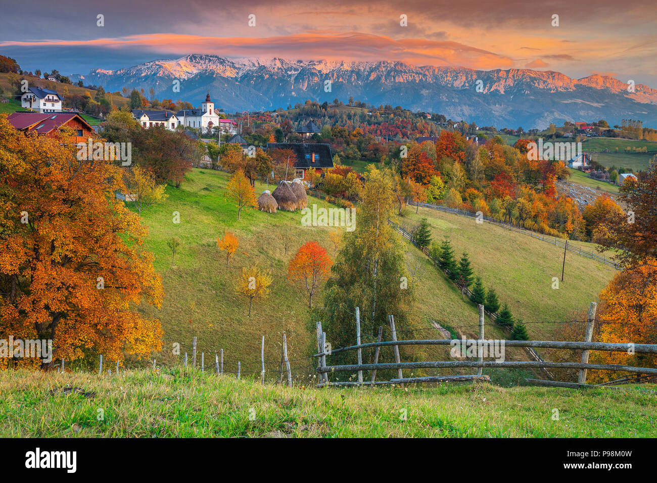 Fantastische Herbst alpine Landschaft, berühmte Alpine Village mit spektakulären Gärten und hohen schneebedeckten Berge im Hintergrund in der Nähe von Bran, Magura, Transylvan Stockfoto