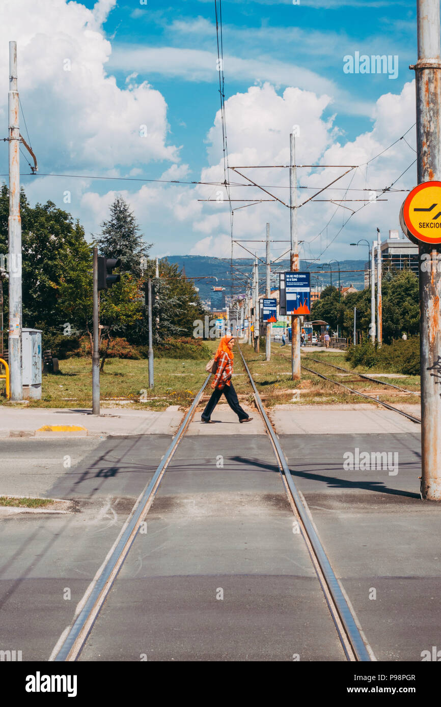 Eine Muslimin überquert die Eisenbahnstrecken in Sarajevo, Bosnien und Herzegowina Stockfoto
