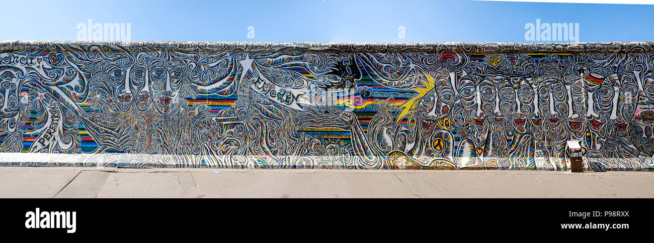 Berlin, Deutschland - Juli 2018: Großes Panorama der Berliner Mauer / East Side Gallery mit einem Teil der Gemälde von schamil Gimajev' Welten, Menschen, wir s Stockfoto
