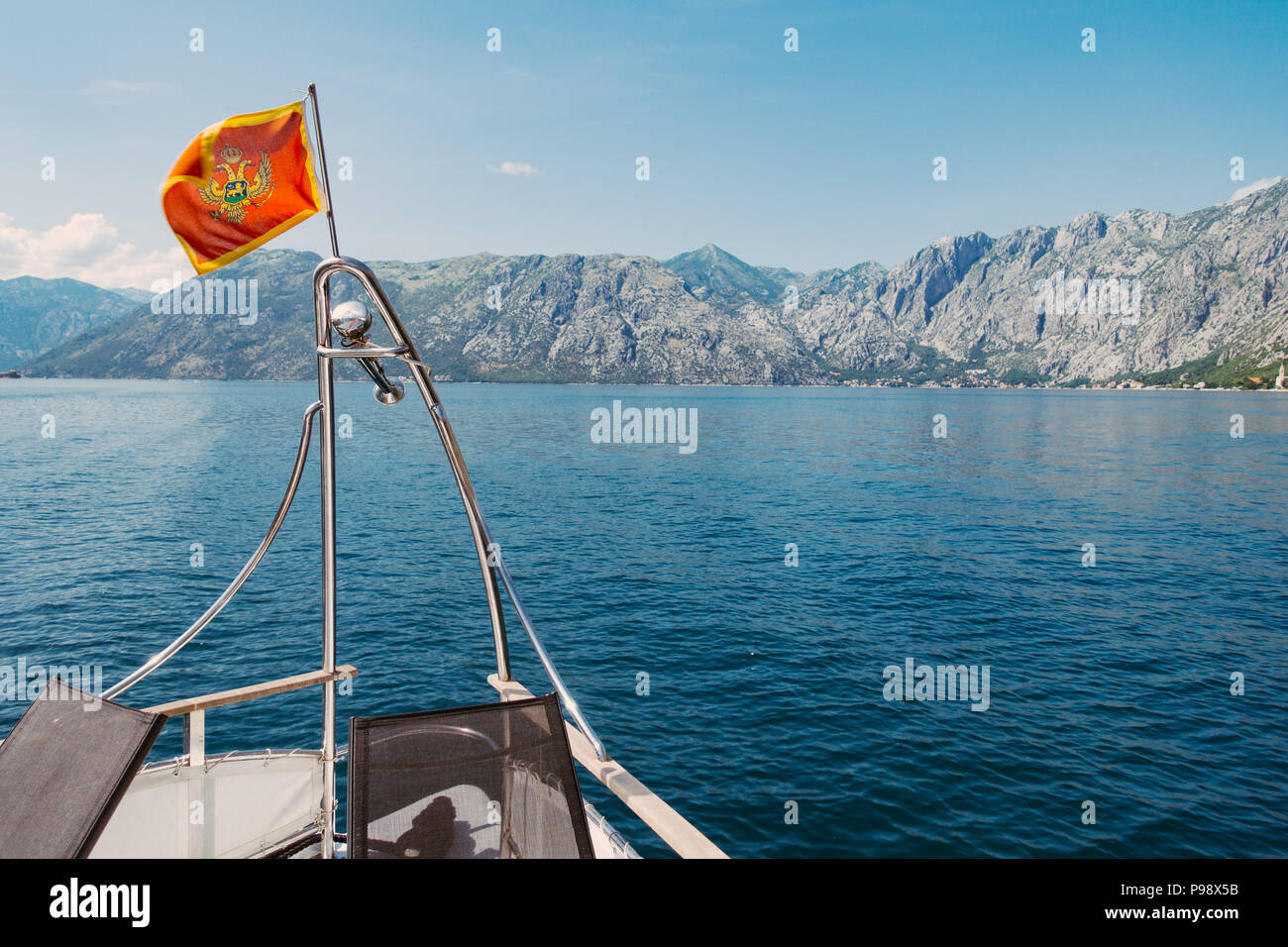 Die montenegrinische Flagge fliegt vom Bug eines Bootes in der Bucht von Kotor, Montenegro Stockfoto