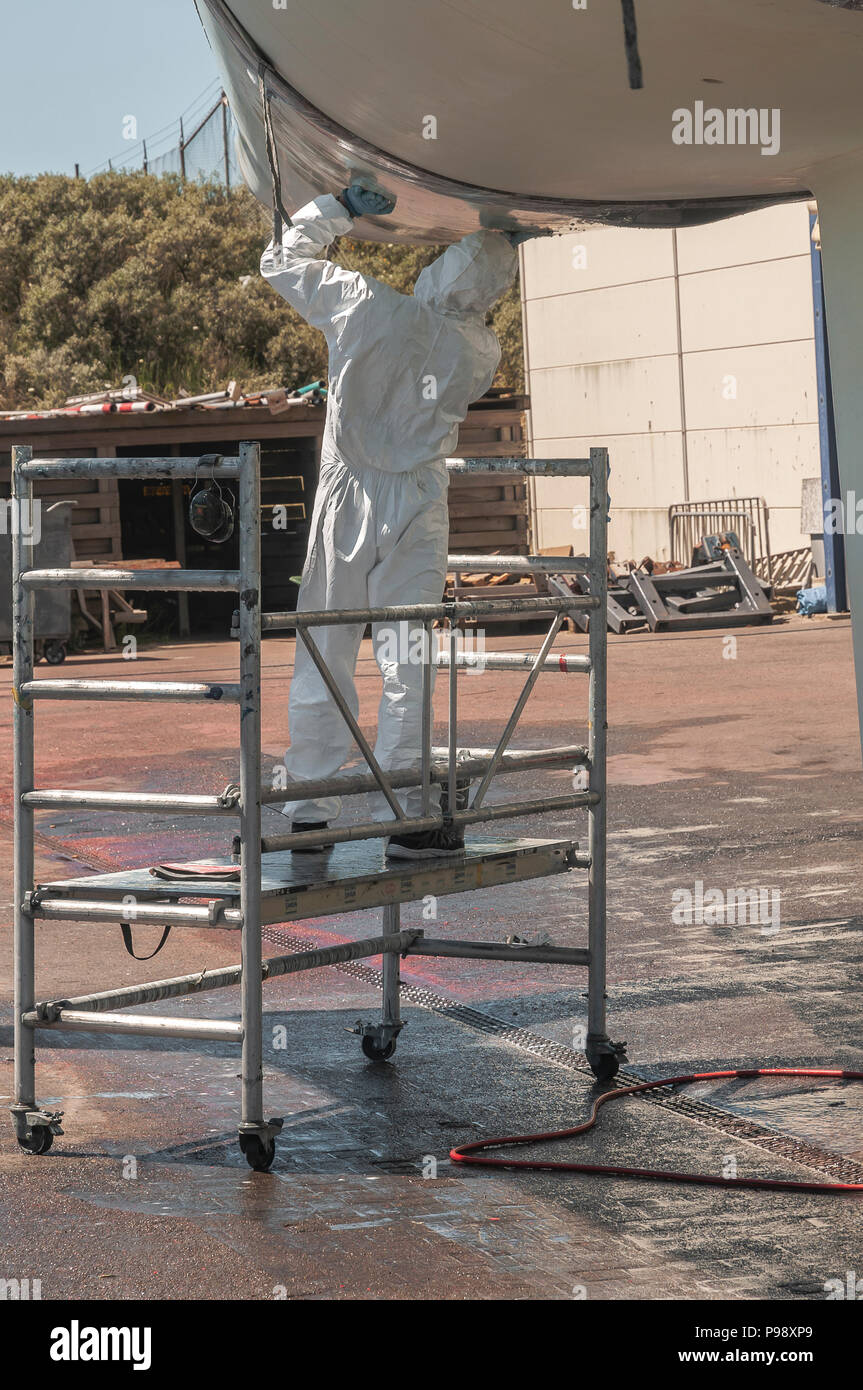 Unten auf einem Katamaran wird durch eine Wartung Arbeiter gereinigt Stockfoto