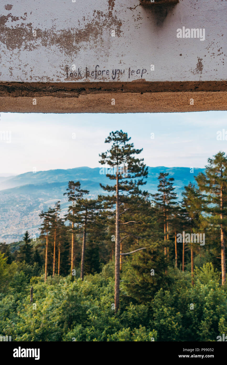 "Schau mal, bevor du springst", geschrieben auf einem Betonbalken im Bistrik Tower, einem verlassenen Fort auf dem Berg Trebević, Sarajevo Stockfoto