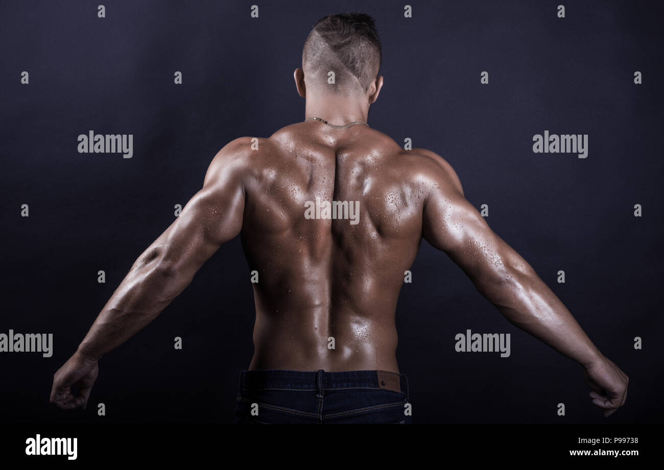 Junge attraktive stattliche muskulös sexy Bodybuilder mit erhobenen Händen zurück Stockfoto