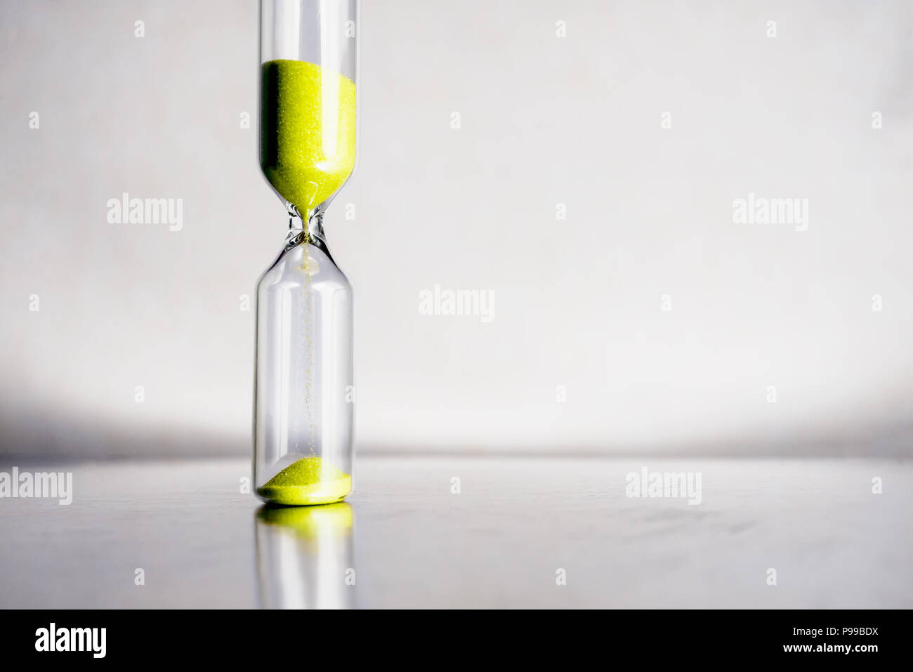Moderne schöne gelbe Sanduhr mit hellen Hintergrund für Kopieren. Sanduhr der Zeit Konzept für die Frist, die Dringlichkeit und die Zeit läuft. Stockfoto