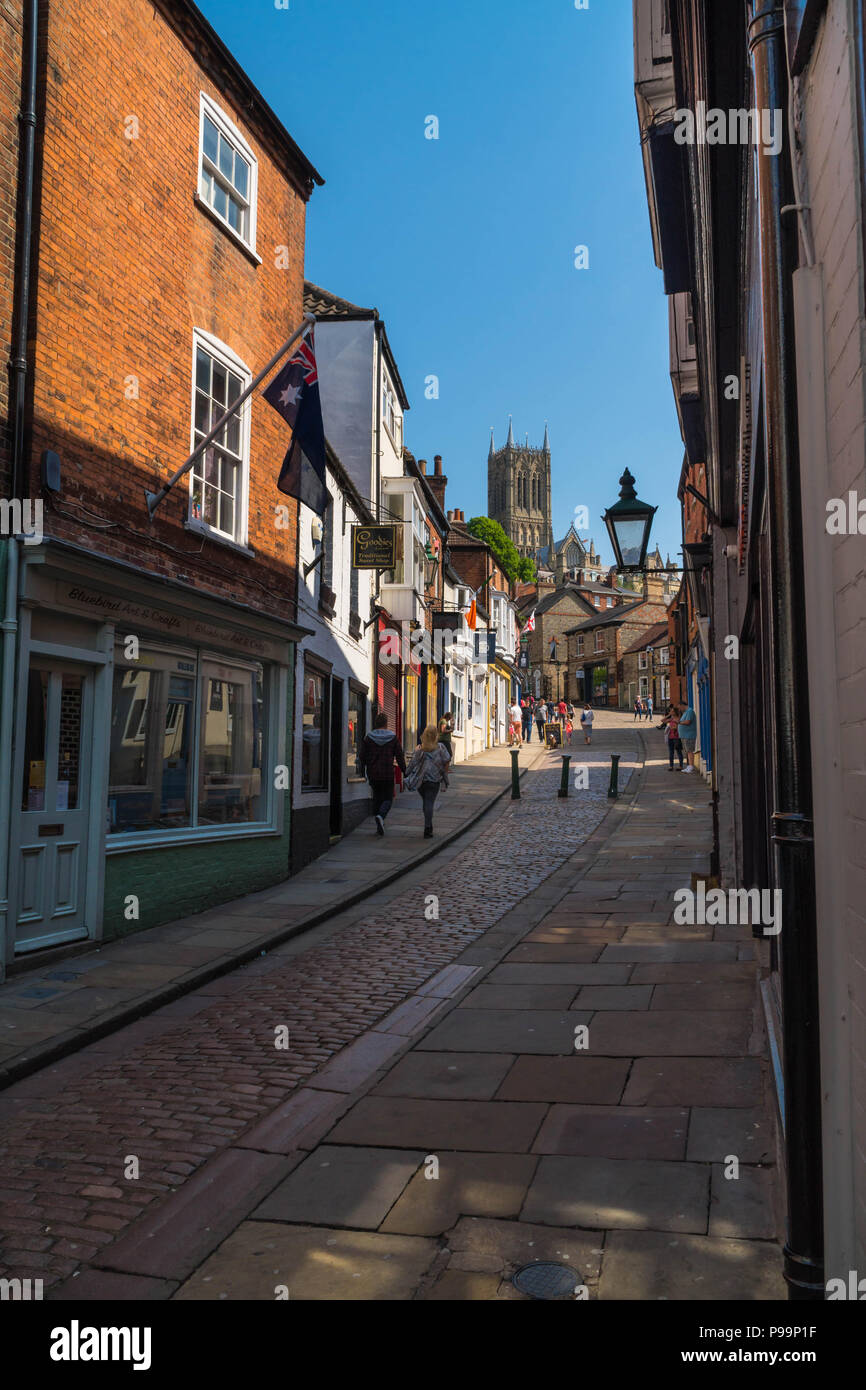 Männliche und weibliche Begegnung mit steilen Hügel eine gepflasterte Straße in Lincoln, die zu der Kathedrale. Lincoln GROSSBRITANNIEN. Mai 2018 Stockfoto