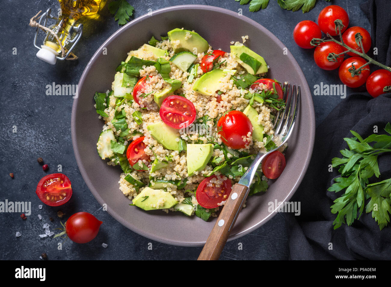 Veganes essen. Quinoa Salat mit Spinat, Avocado und Tomaten auf dunklen Tisch aus Stein. Close Up. Stockfoto