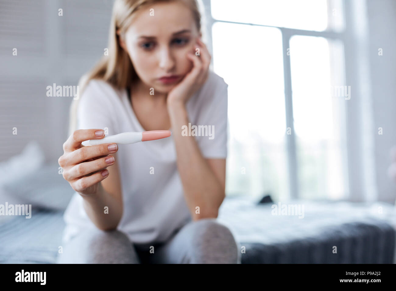 Traurige Frau ihre Schwangerschaft Test Holding Stockfoto