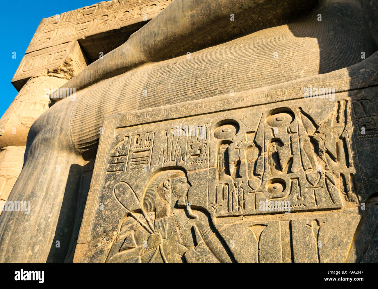 Nahaufnahme Detail aus Granit gehauen Hieroglyphen an der Basis der Kolosse sitzende Figur von Ramses II., den Tempel von Luxor, Luxor, Ägypten, Afrika Stockfoto