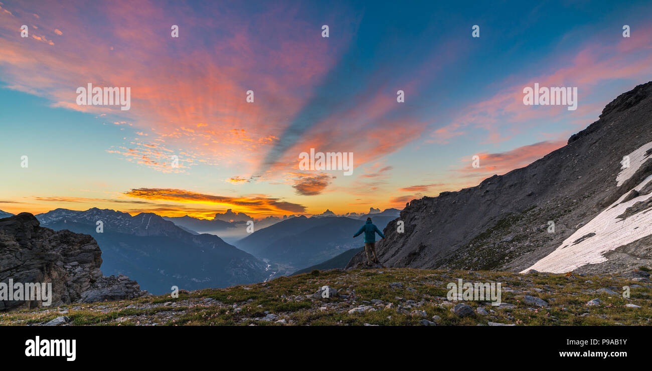 Mann, der auf dem Berg oben Anheben der Arme, sunrise licht bunt Sky scenis Landschaft, die Eroberung des Erfolg LEADER-Konzept. Stockfoto