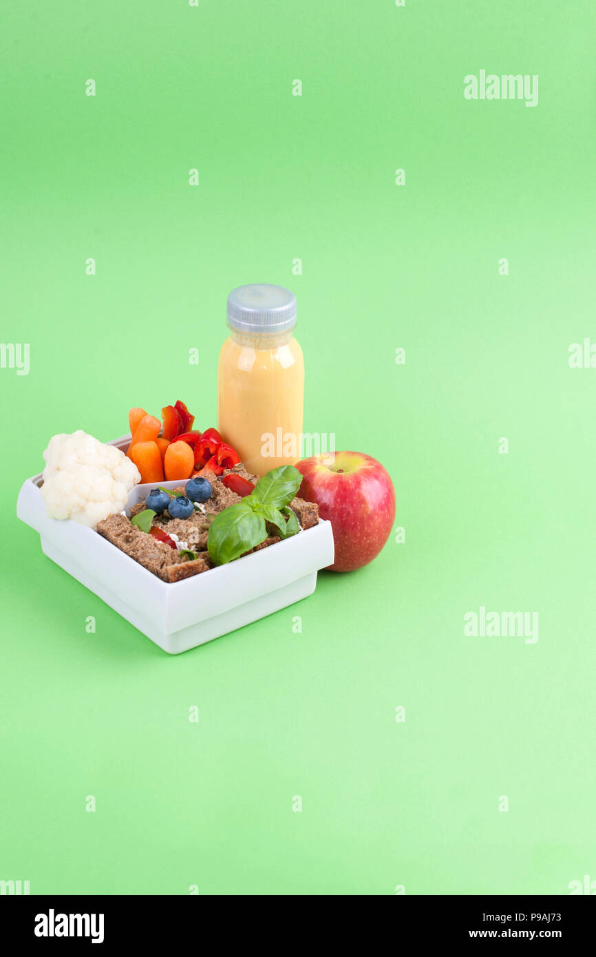 In einem Kasten und Saft mit Obst auf einem grünen Hintergrund Mittagessen. Freier Platz für Text. Platz kopieren Stockfoto