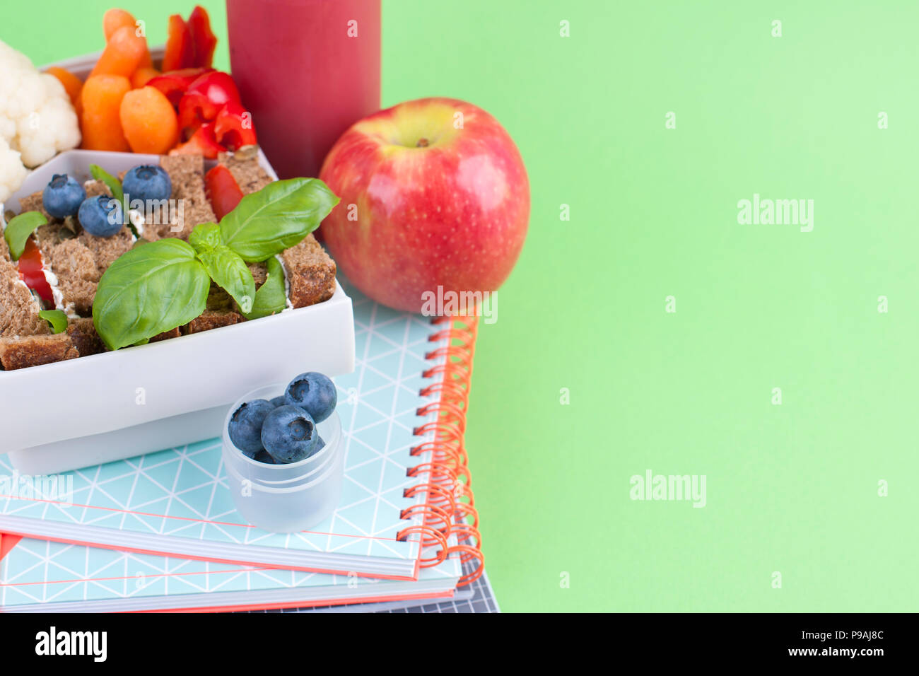 Schule Mittagessen in einer Box und Saft mit Obst auf einem grünen Hintergrund. Freier Platz für Text. Platz kopieren Stockfoto