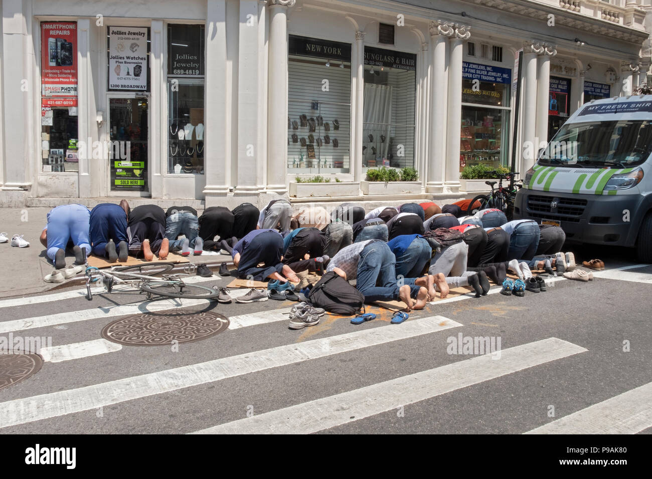 Eine Gruppe von muslimischen Männern an ihren regelmäßigen Freitag nachmittag Gebet am Broadway und West 29. Straße in Manhattan, New York City Stockfoto