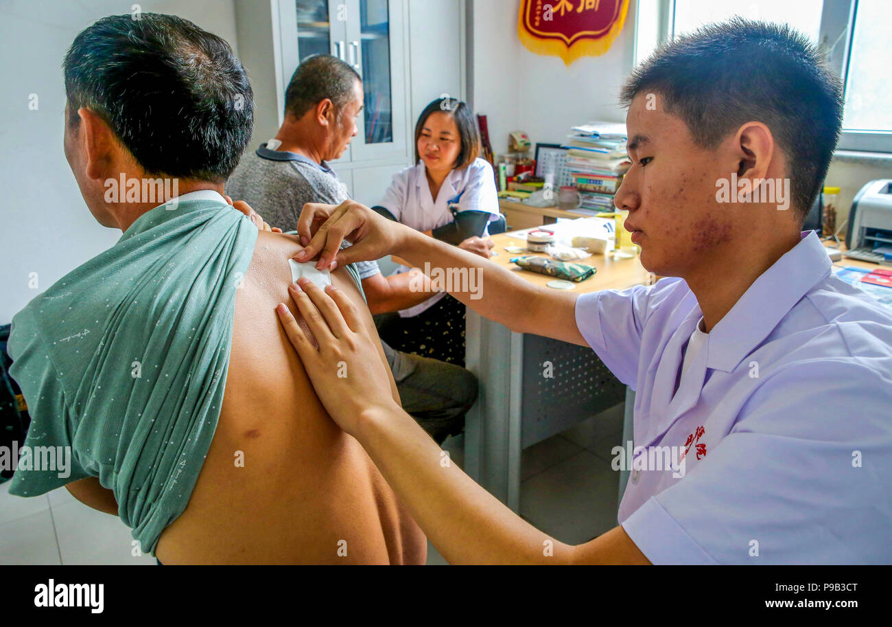 (180717) -- RAOYANG, 17. Juli 2018 (Xinhua) - Ärzte Praxis kraut Therapie für die Bürger bei der Menschen Krankenhaus von Raoyang County, im Norden der chinesischen Provinz Hebei, 17. Juli 2018. Als der heisseste Teil der Sommer in China beginnt, viele Menschen kommen zu den Krankenhäusern der Traditionellen Chinesischen Medizin Krankheit durch Anwendung von Kraut sticks Punkte der Akupunktur zu verhindern. (Xinhua/Li Xiaoguo) (hxy) Stockfoto