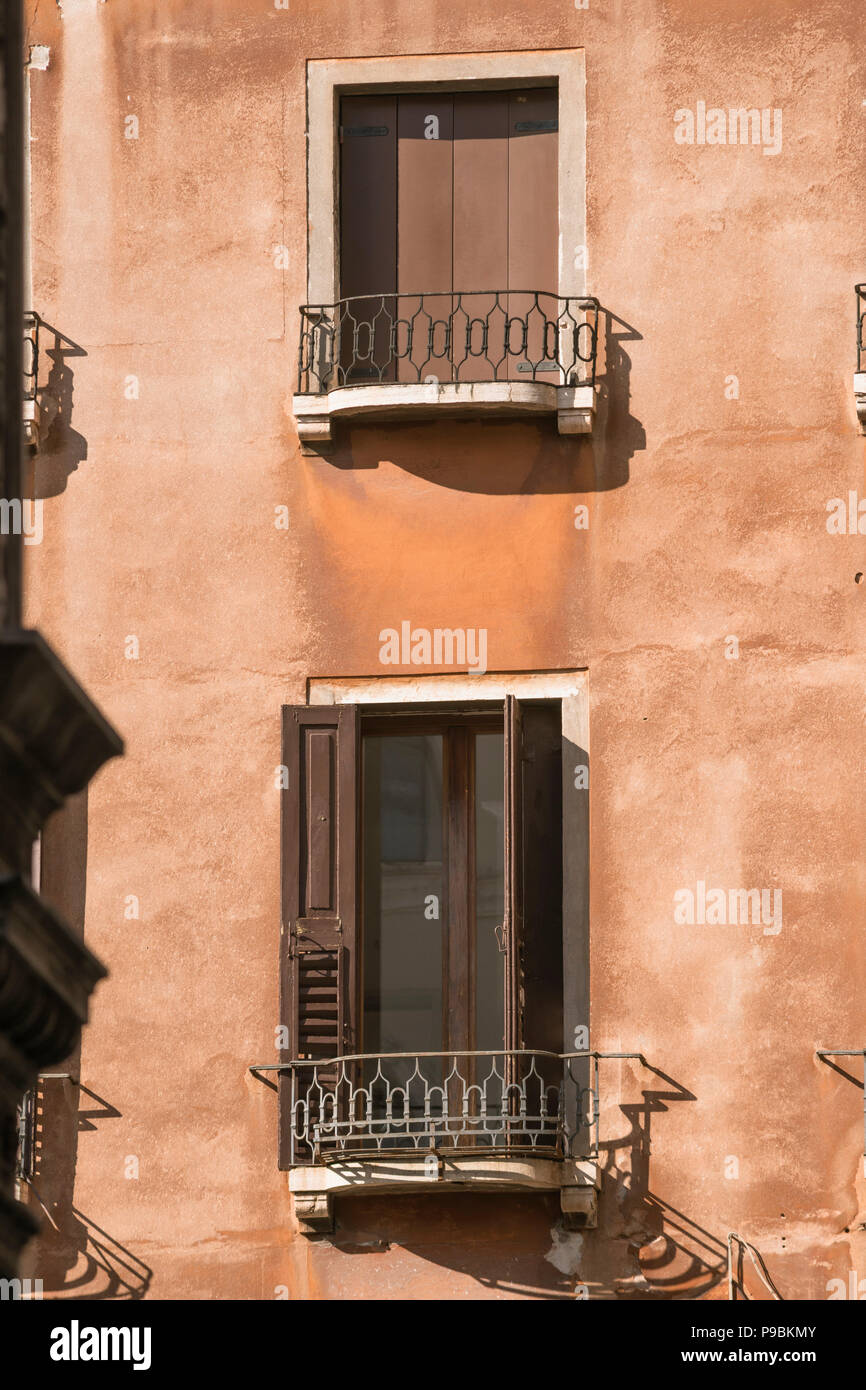 Zwei Fensterläden auf alten Gebäudewand Stockfoto