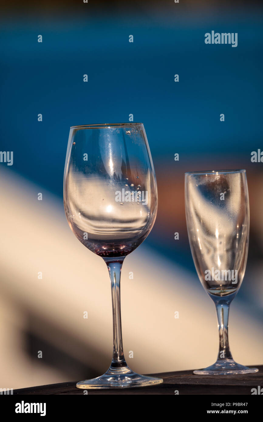 Leere Glas Wein und Champagner Flöte auf einem Tisch am Strand in Florida. Stockfoto