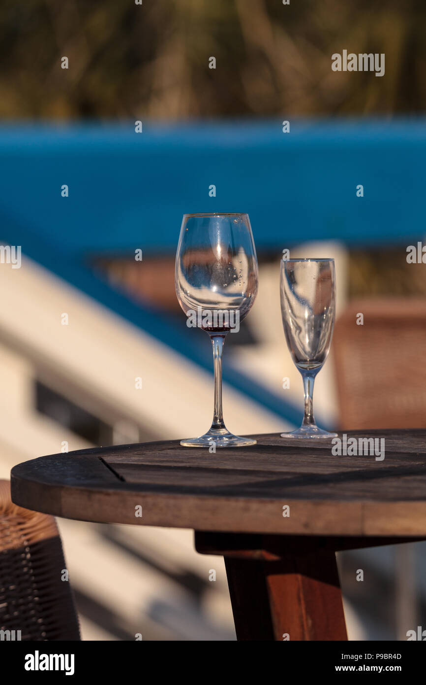 Leere Glas Wein und Champagner Flöte auf einem Tisch am Strand in Florida. Stockfoto
