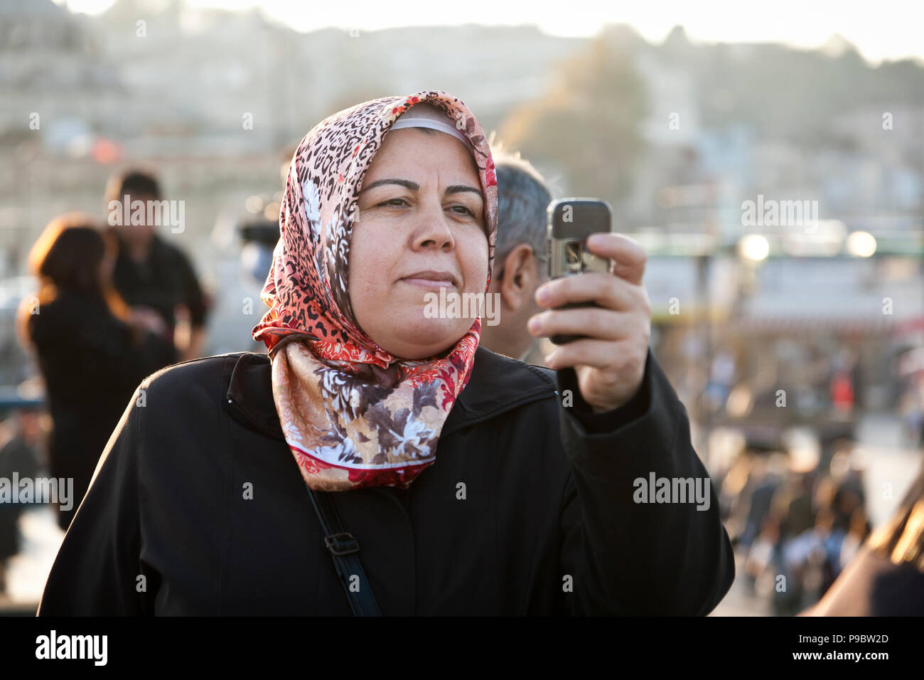 Istanbul, Türkei - 6 November 2009: Frau mit Kopftuch mit Ihrem Mobiltelefon ein Foto während der Galata Brücke in Istanbul zu nehmen Stockfoto