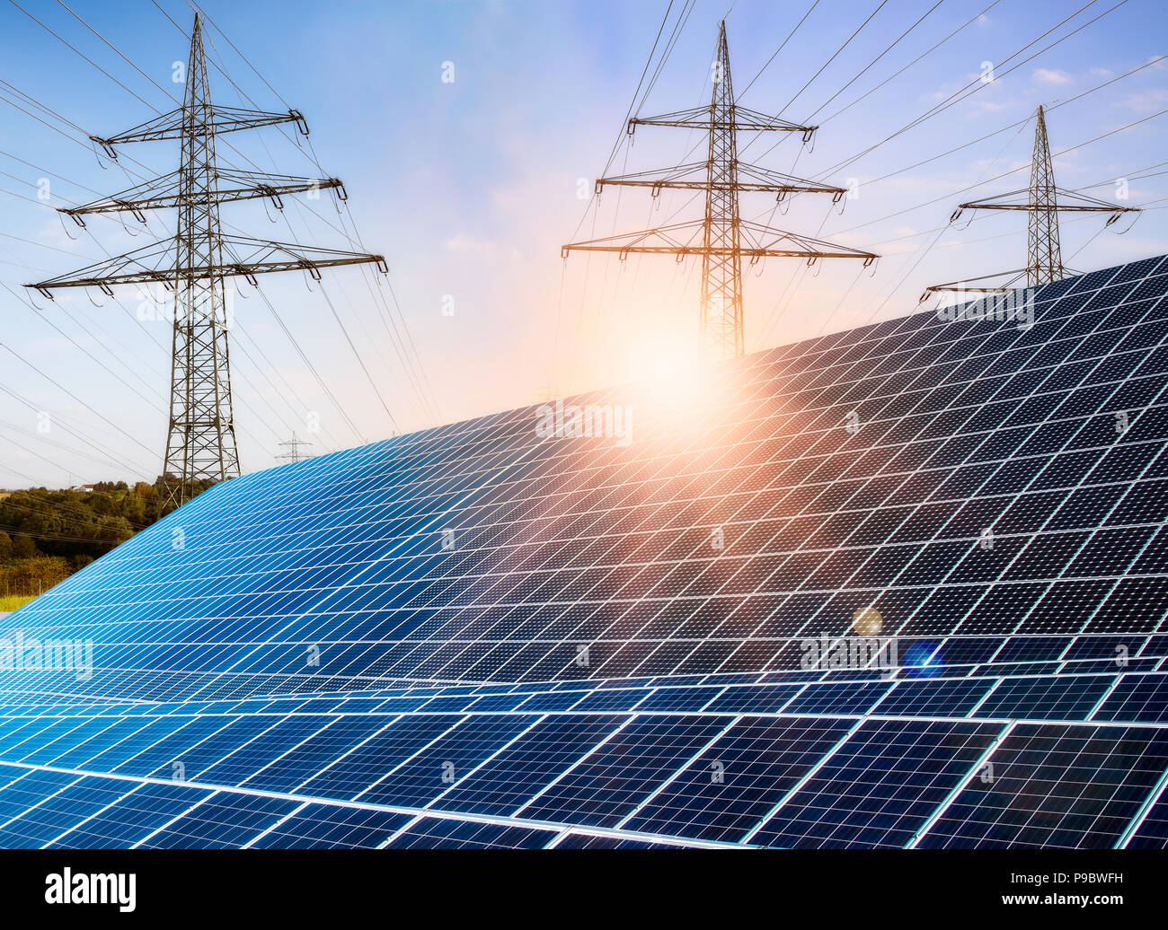 Photovoltaikanlage mit Strommasten und Sonnenschein Stockfoto