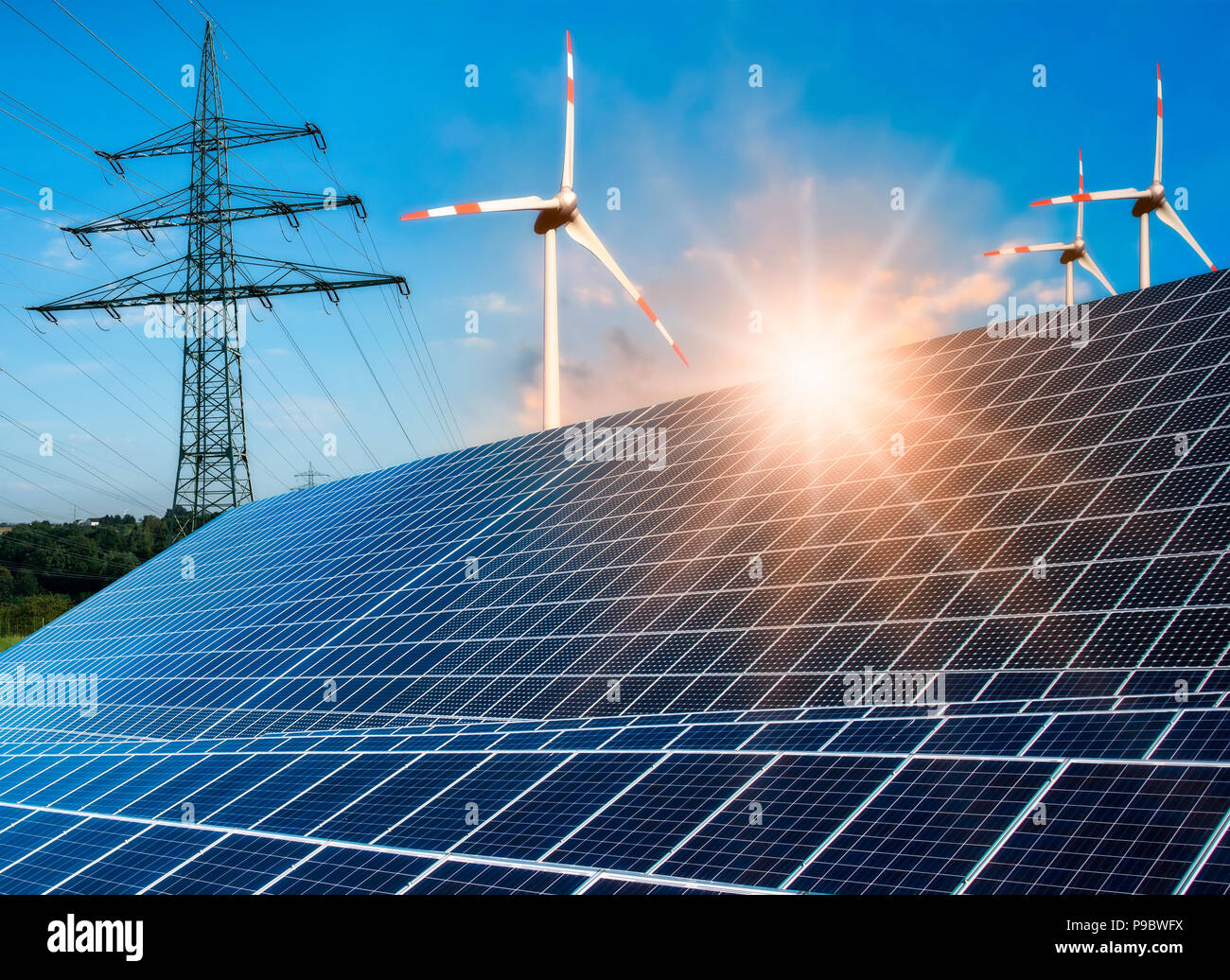 Photovoltaikanlage, wind turbine und Strommast mit hellen Sonne Stockfoto