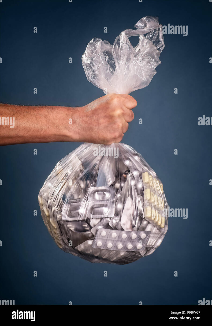 Hand hält eine Plastiktüte mit vielen Arzneimitteln Stockfoto
