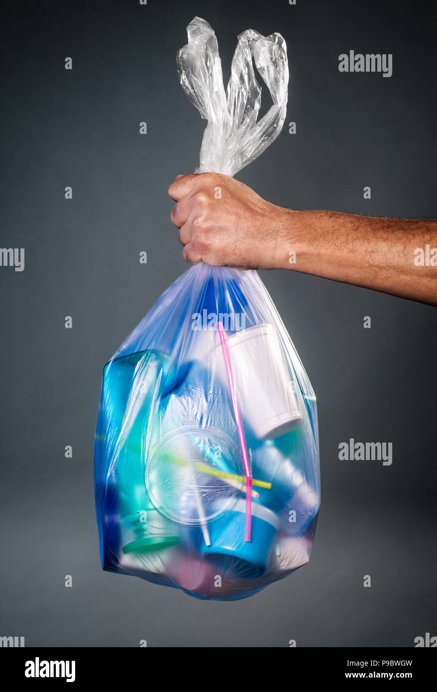 Hand, die eine Tasche von Kunststoffabfällen Stockfoto