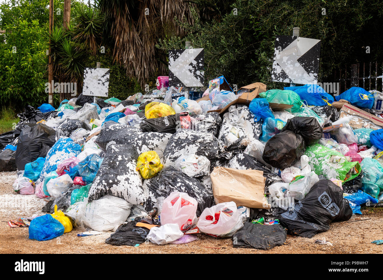 Gestapelte Mülltüten auf einer Straße auf der griechischen Insel Korfu Stockfoto