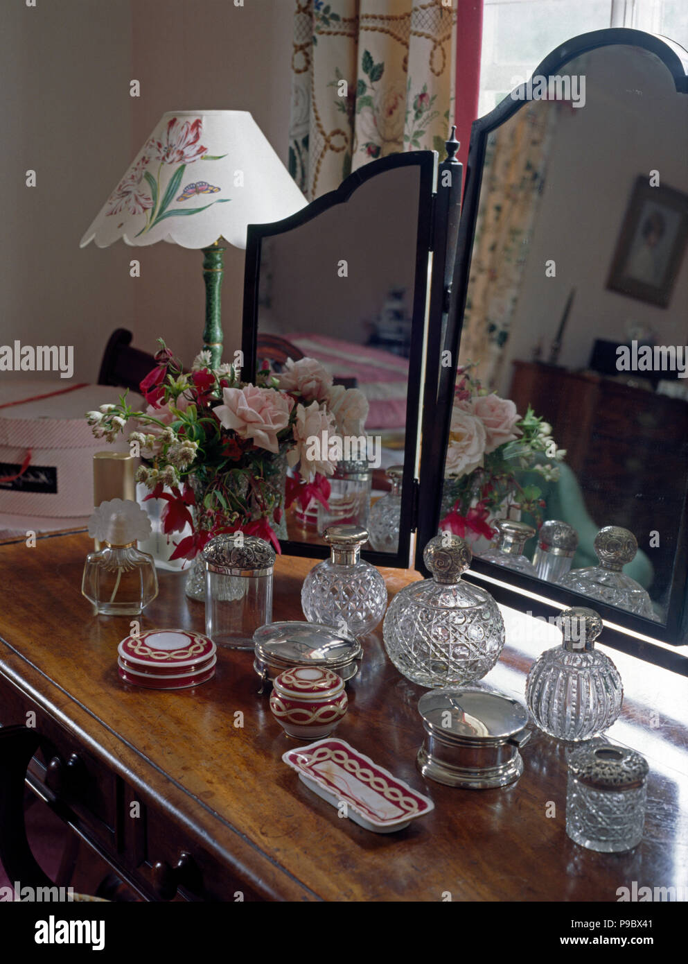 Nahaufnahme einer Sammlung von Vintage Glasflaschen auf Frisiertisch mit drei Spiegeln Stockfoto
