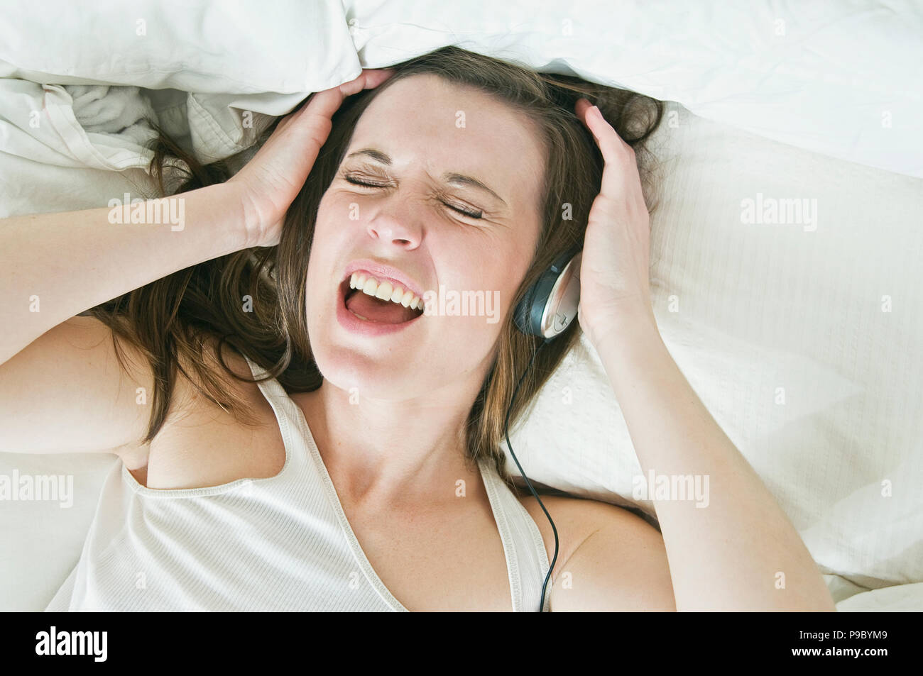 Eine Frau, die Musik auf Ihre Kopfhörer und Singen. Stockfoto