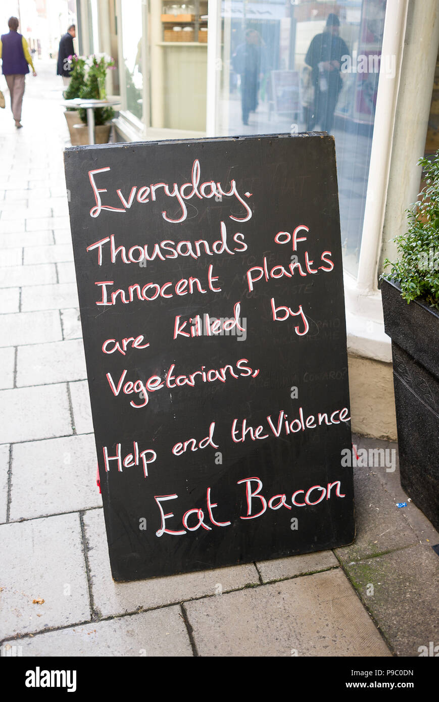 Amüsante Bekanntmachung außerhalb eines Metzger shop Menschen ermutigen, Speck in Großbritannien zu essen Stockfoto