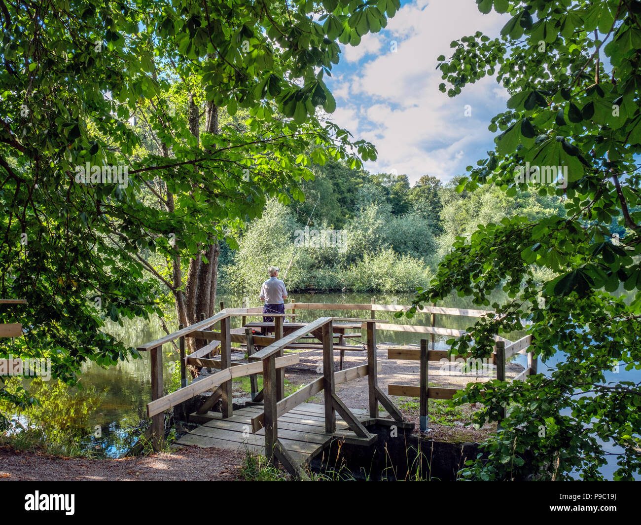 Nicht erkennbare Mann angeln in der City Park entlang der Fluss Motala in Norrköping. Norrköping ist eine historische Stadt in Schweden. Stockfoto