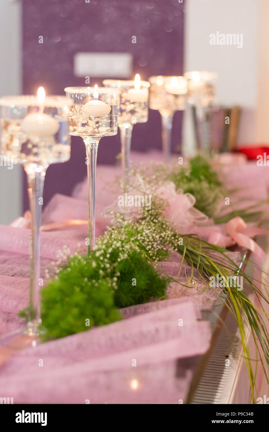 Rosa Blumen, Schleifen und elegante Kerzen sind die perfekte Hochzeit Dekorationen Stockfoto