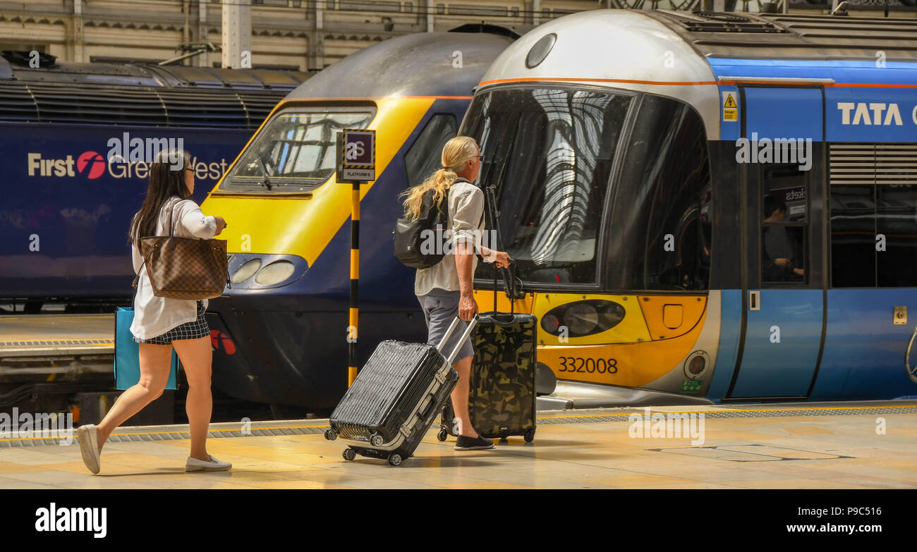 Fahrgäste entlang eine Plattform am Londoner Bahnhof Paddington und dem Heathrow Express an Bord Stockfoto