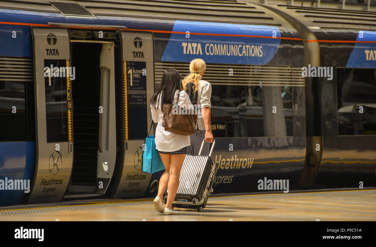Fahrgäste entlang eine Plattform am Londoner Bahnhof Paddington und dem Heathrow Express an Bord Stockfoto