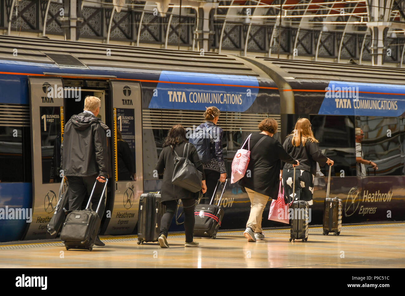 Fahrgäste entlang eine Plattform am Londoner Bahnhof Paddington und dem Heathrow Express an Bord Stockfoto