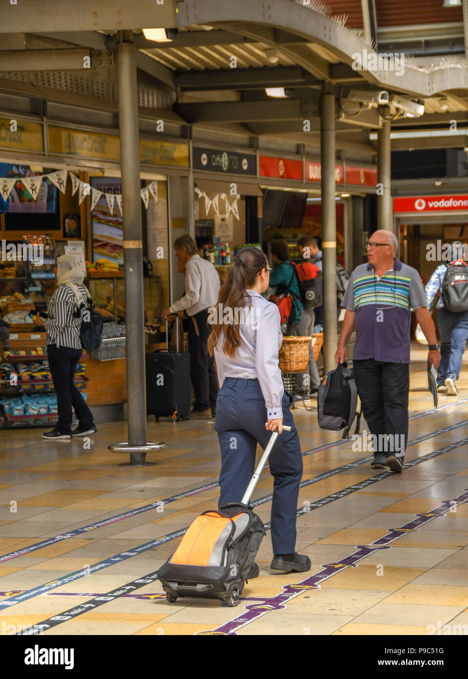 Passagier entlang der Bahnhofshalle in London Paddington Bahnhof ziehen einen Koffer Stockfoto