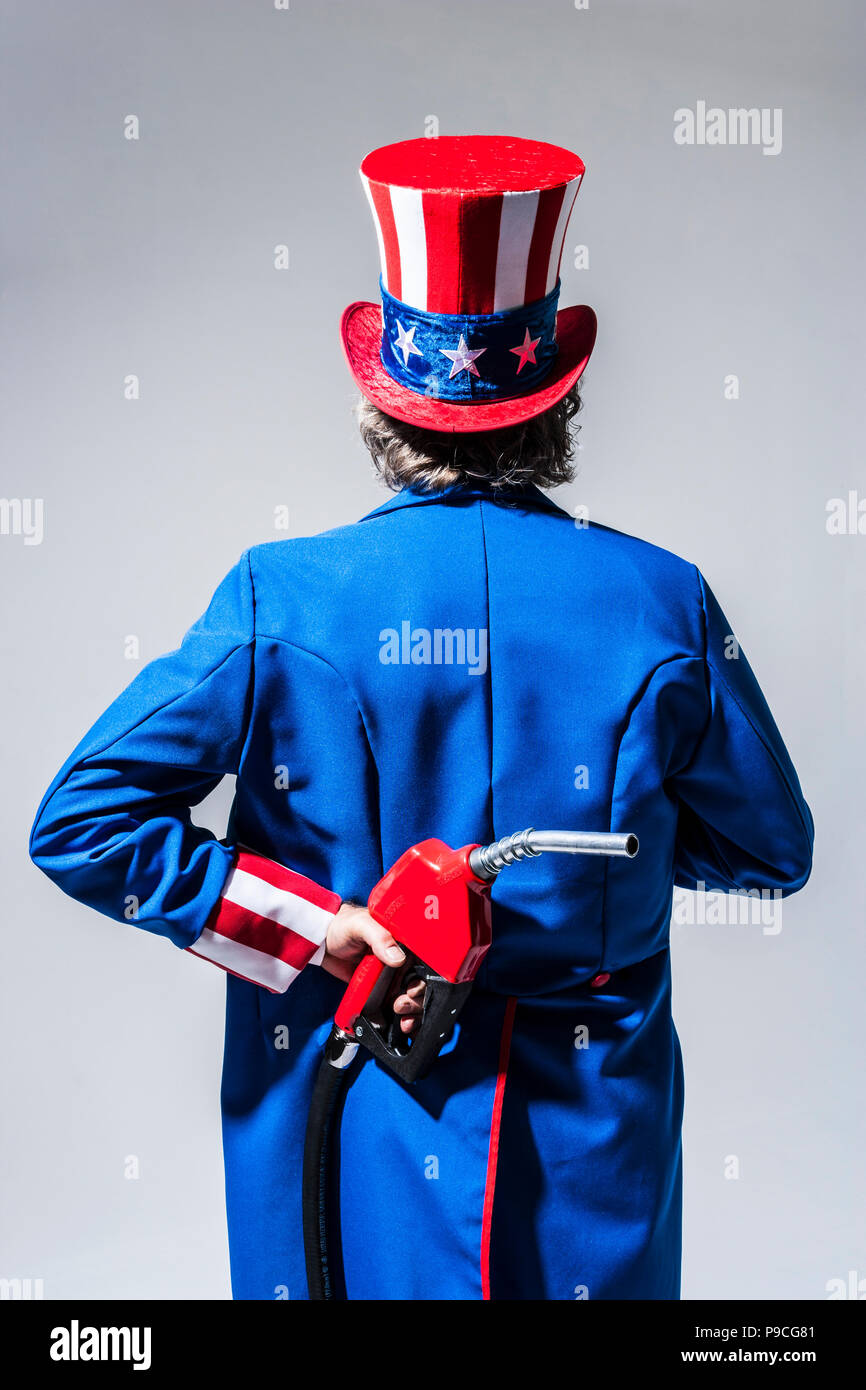 Uncle Sam-Figur von hinten mit einem Benzin pumpe Düse hinter seinem Rücken gesehen. Stockfoto
