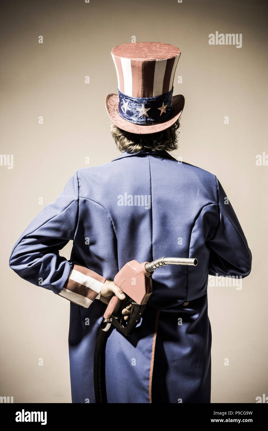 Uncle Sam-Figur von hinten mit einem Benzin pumpe Düse hinter seinem Rücken gesehen. Stockfoto