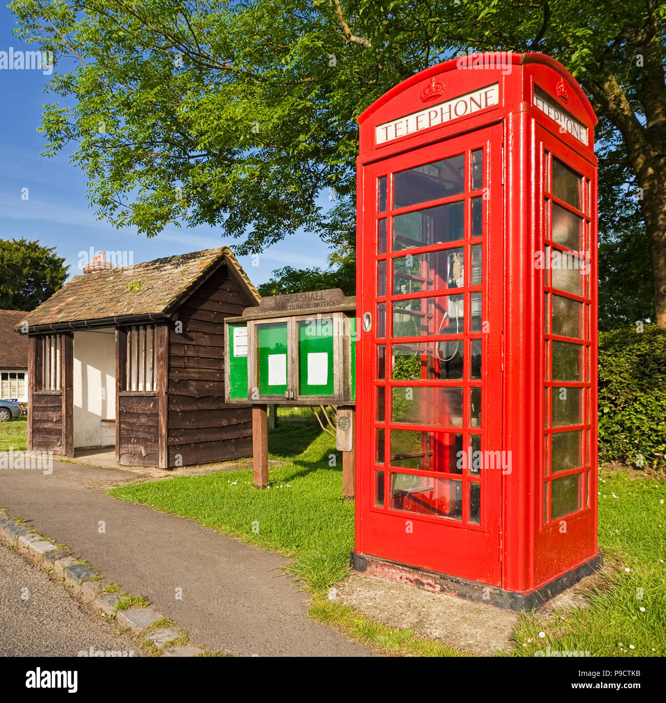 Traditionelle britische rote Telefonzelle, Bushaltestelle und Dorf Aushang Szene an Lurgashall, West Sussex, England, Großbritannien Stockfoto